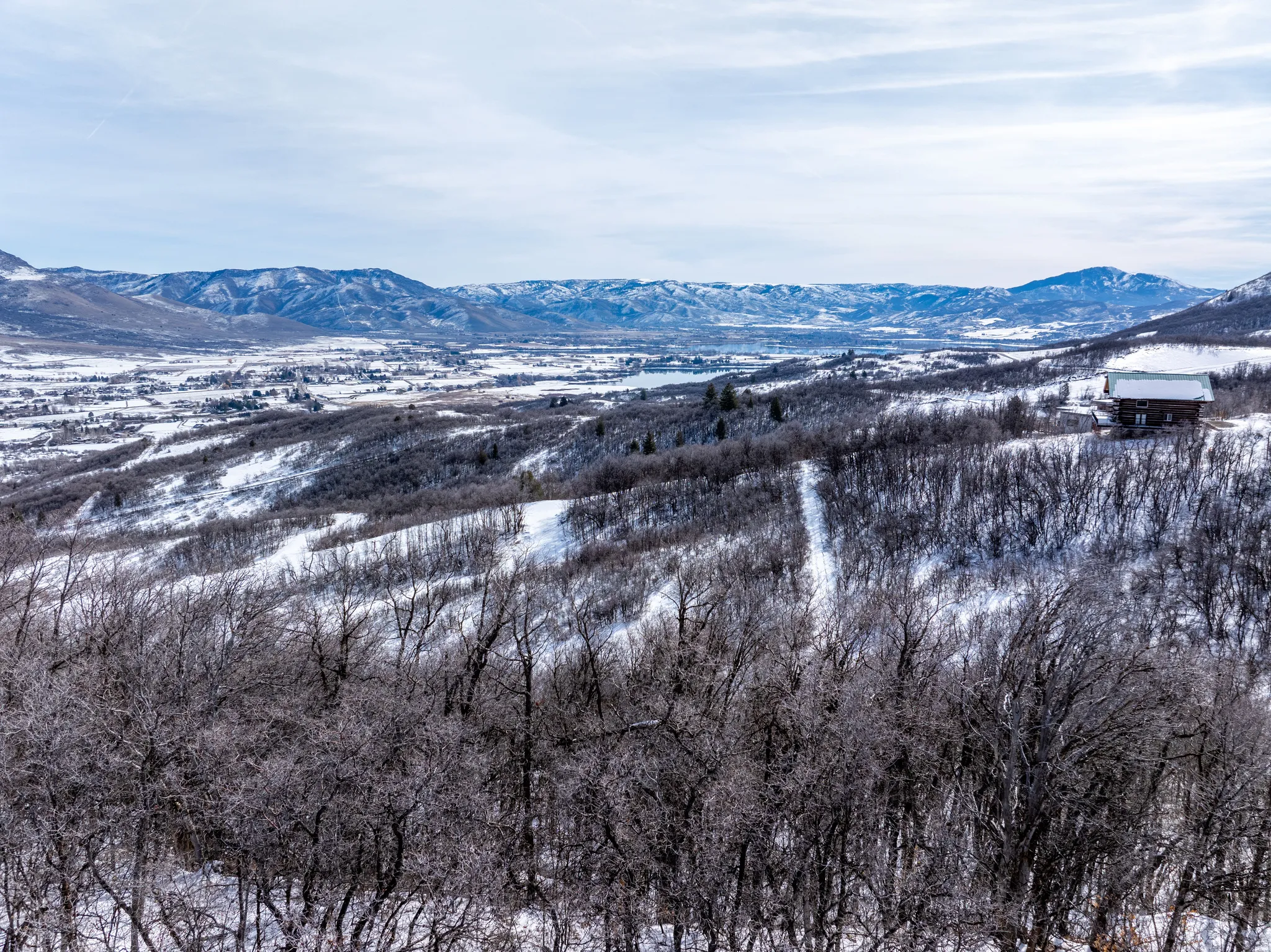 Snow-covered mountain landscape featuring a distant valley and a singular structure