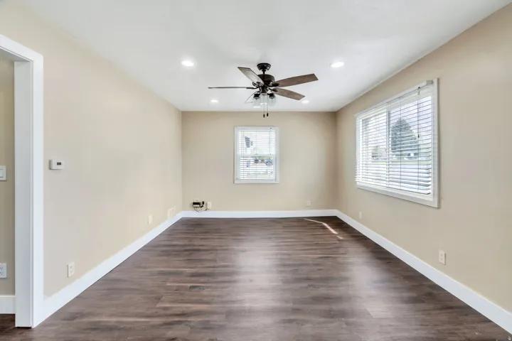 Spacious room featuring wood-finish flooring, recessed lighting, and a ceiling fan