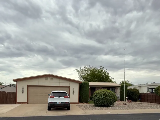 Front exterior with an attached two-car garage, concrete driveway, and gravel landscaping
