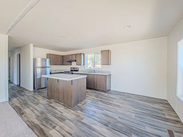 Kitchen featuring a central island, wood-finish flooring, recessed lighting, stainless steel appliances, and wood cabinetry