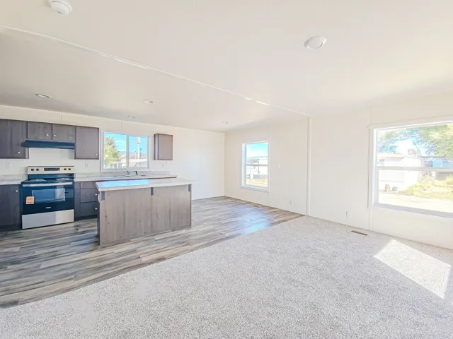Open-concept living space with dark wood-finish cabinetry, light countertops, and a kitchen island