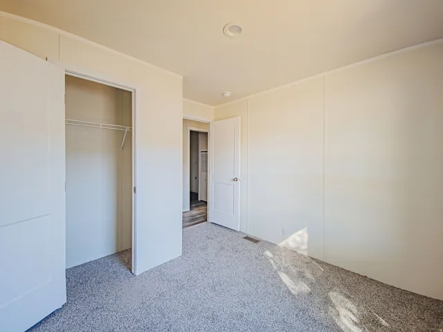Recessed lighting, light-colored walls, and gray carpeting