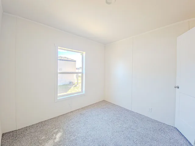 Textured wall panels with white trim, gray carpet, and a single window with white framing