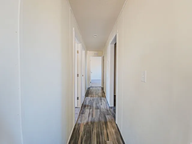 Hallway featuring wood-finish flooring and light-toned walls