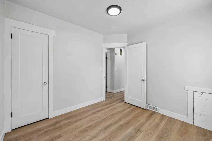 Recessed ceiling light fixture, light wood-finish flooring, white trim, white panel doors, and light gray wall paint