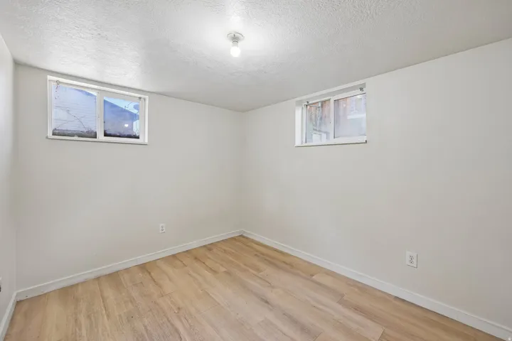 Recessed windows, wood-finish flooring, white walls, and ceiling-mounted lighting