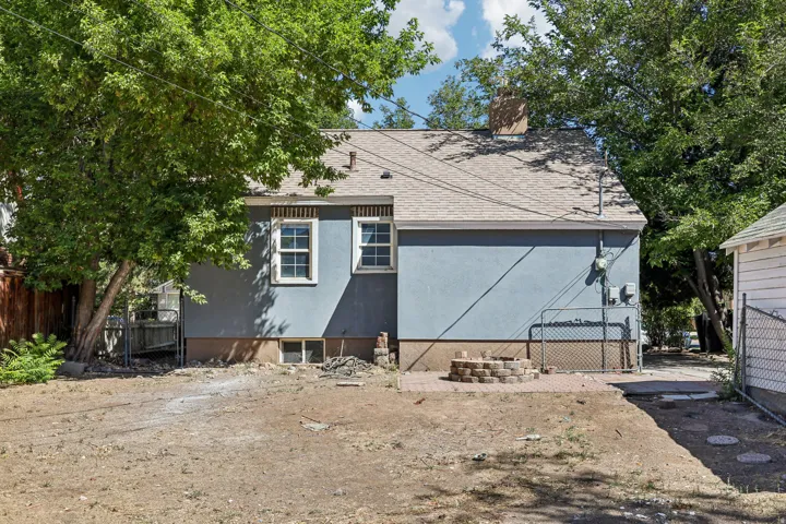 Blue exterior with white window trim, asphalt shingle roof, and a brick chimney