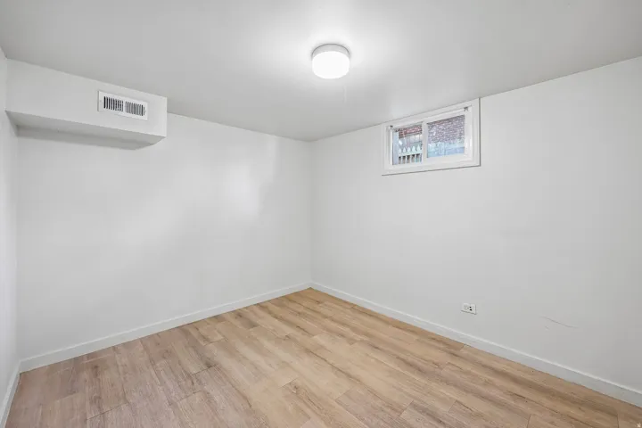 Wood-finish flooring, white walls, and a window for natural illumination