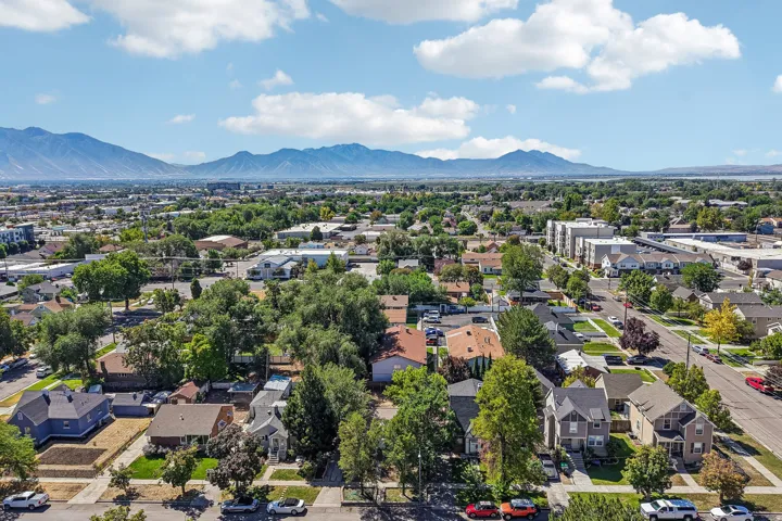 Aerial view showcasing a tree-lined residential neighborhood with mature landscaping, diverse architectural styles, and established homes situated on spacious lots