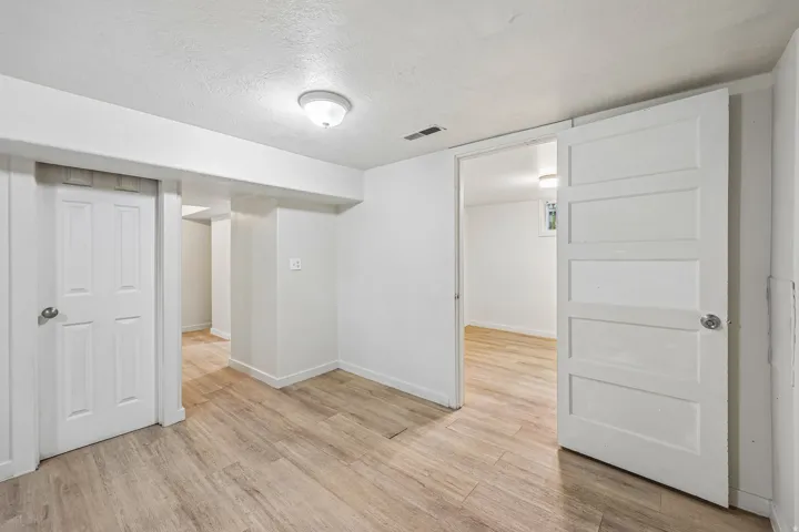 Recessed ceiling light fixtures, white paneled doors, and wood-finish flooring