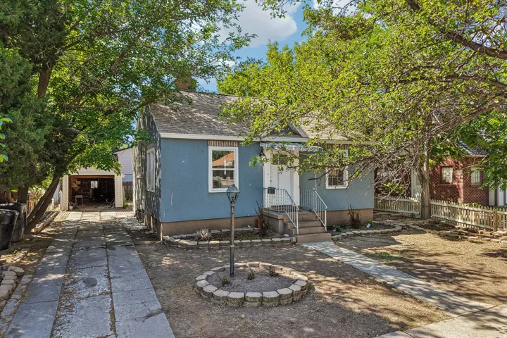Single-story residence featuring light blue siding, white trim windows, and a covered entry