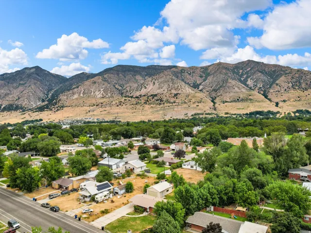 Expansive mountain range backdrop framing a residential area with mature tree coverage and established homes