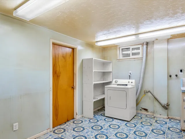 Laundry area with patterned blue and white floor tiles