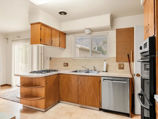 Kitchen featuring wood cabinetry, a stainless steel dishwasher, a built-in oven, and a gas cooktop