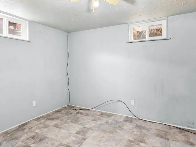 Room featuring two windows, light blue walls, and patterned tile flooring