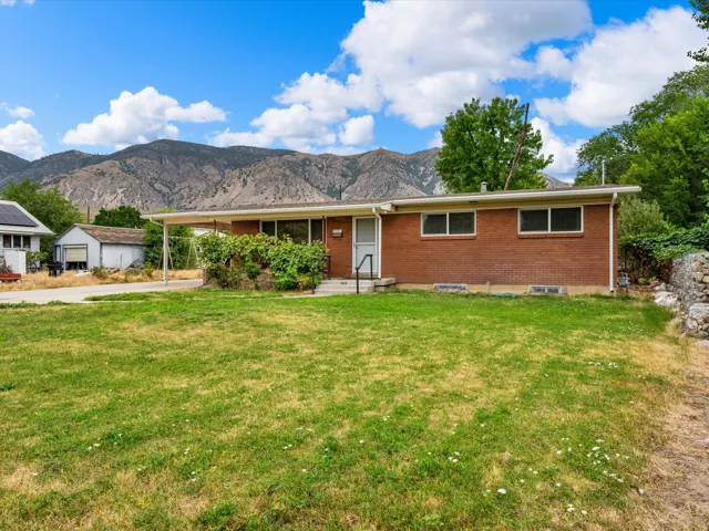 Brick exterior home featuring an expansive front lawn