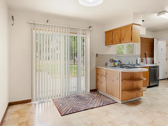 Kitchen area featuring a built-in cooktop, integrated dishwasher, and wood cabinetry
