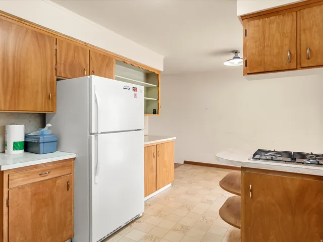 Kitchen featuring wood cabinetry, laminate countertops, and patterned floor tiles