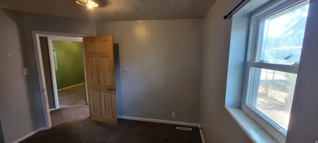 Neutral-toned room with a wooden panel door and a single window