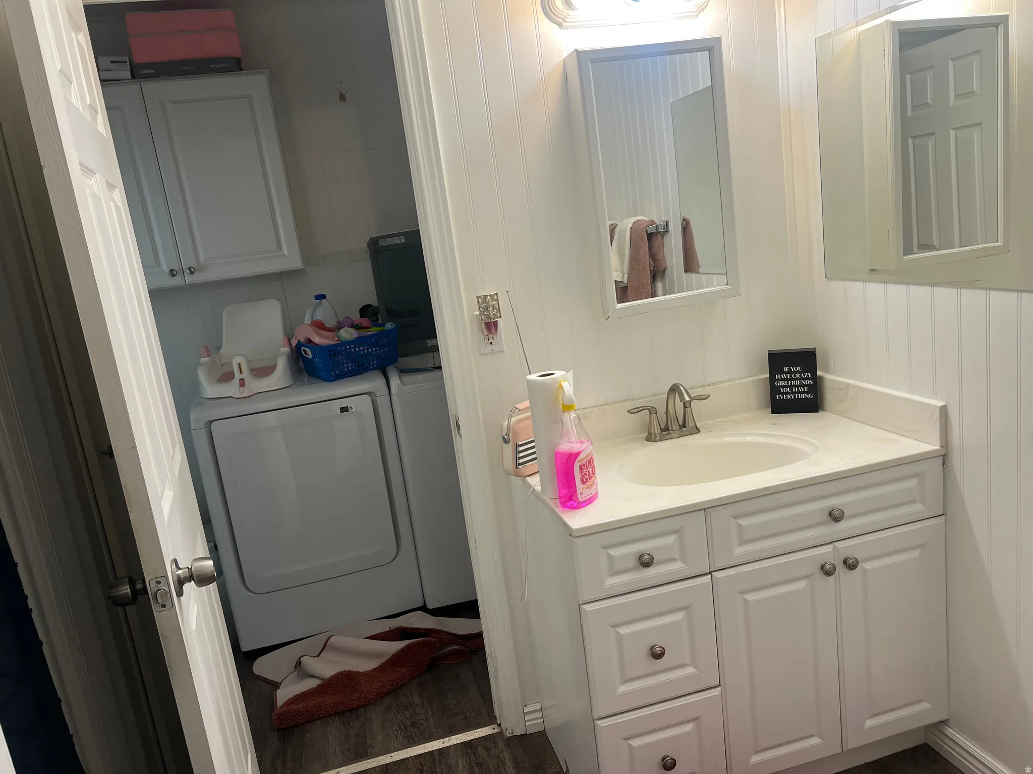 Vanity with a single basin sink, brushed nickel faucet, and white shaker-style cabinetry. Door to Laundry Room