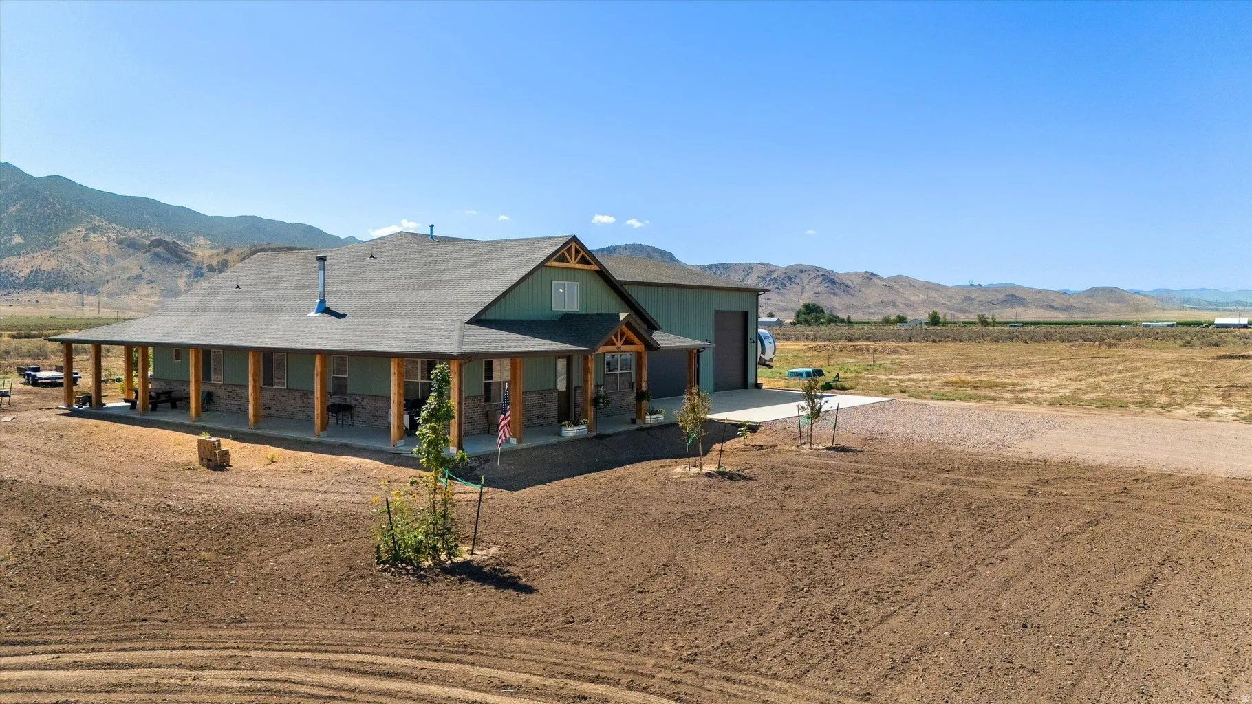 Ranch-style residence featuring a broad covered porch, stone accent siding, and a gabled roofline