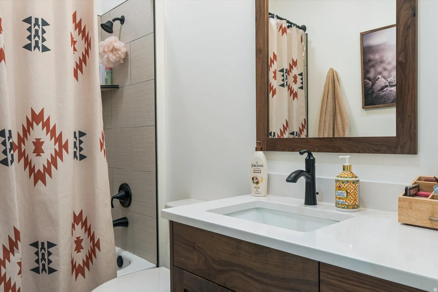 Bathroom vanity with an integrated rectangular sink, white countertop, and dark wood-finish cabinetry