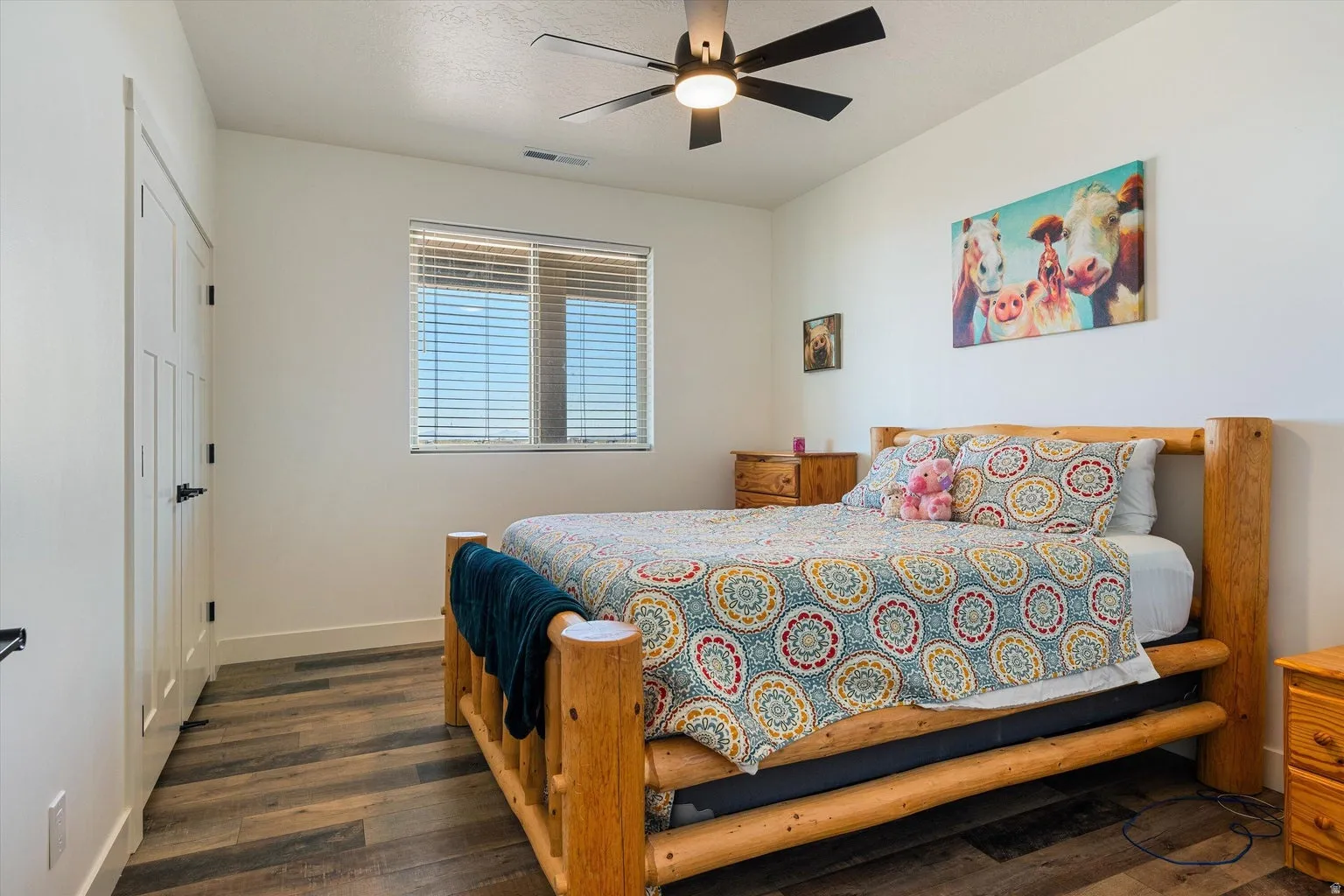 Bright room featuring a window with horizontal blinds, wood-finish flooring, and a ceiling fan with integrated lighting
