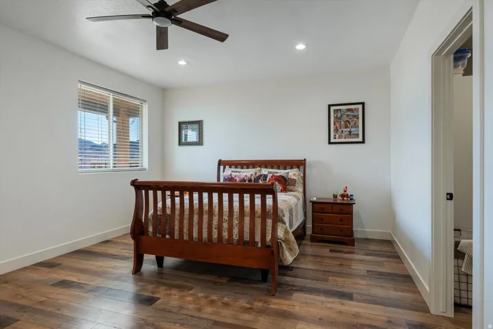 Spacious room featuring wood-finish flooring, a ceiling fan with integrated lighting, and recessed ceiling lights