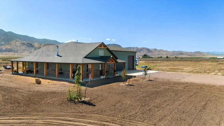 Ranch-style residence featuring a broad covered porch, stone accent siding, and a gabled roofline