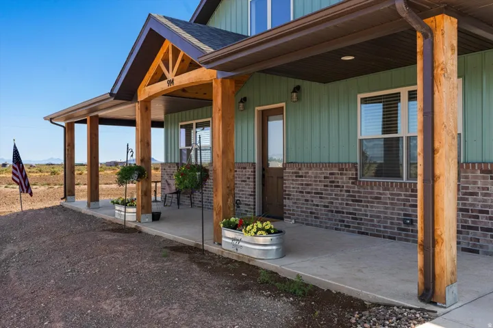 Covered front porch featuring rustic wood columns and a concrete surface