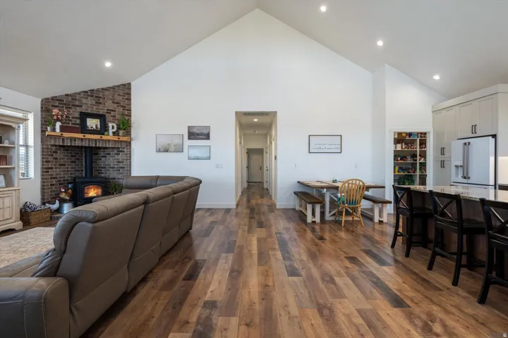 Vaulted ceilings enhance this open-concept living space, featuring wood-finish flooring throughout