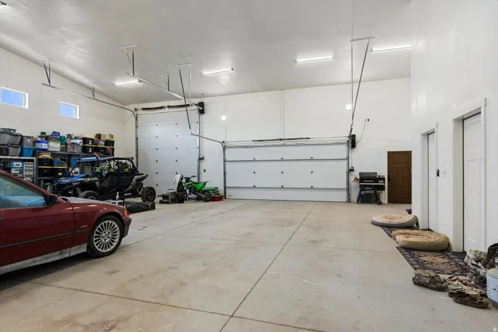 Expansive garage space featuring a vaulted ceiling and two large overhead doors