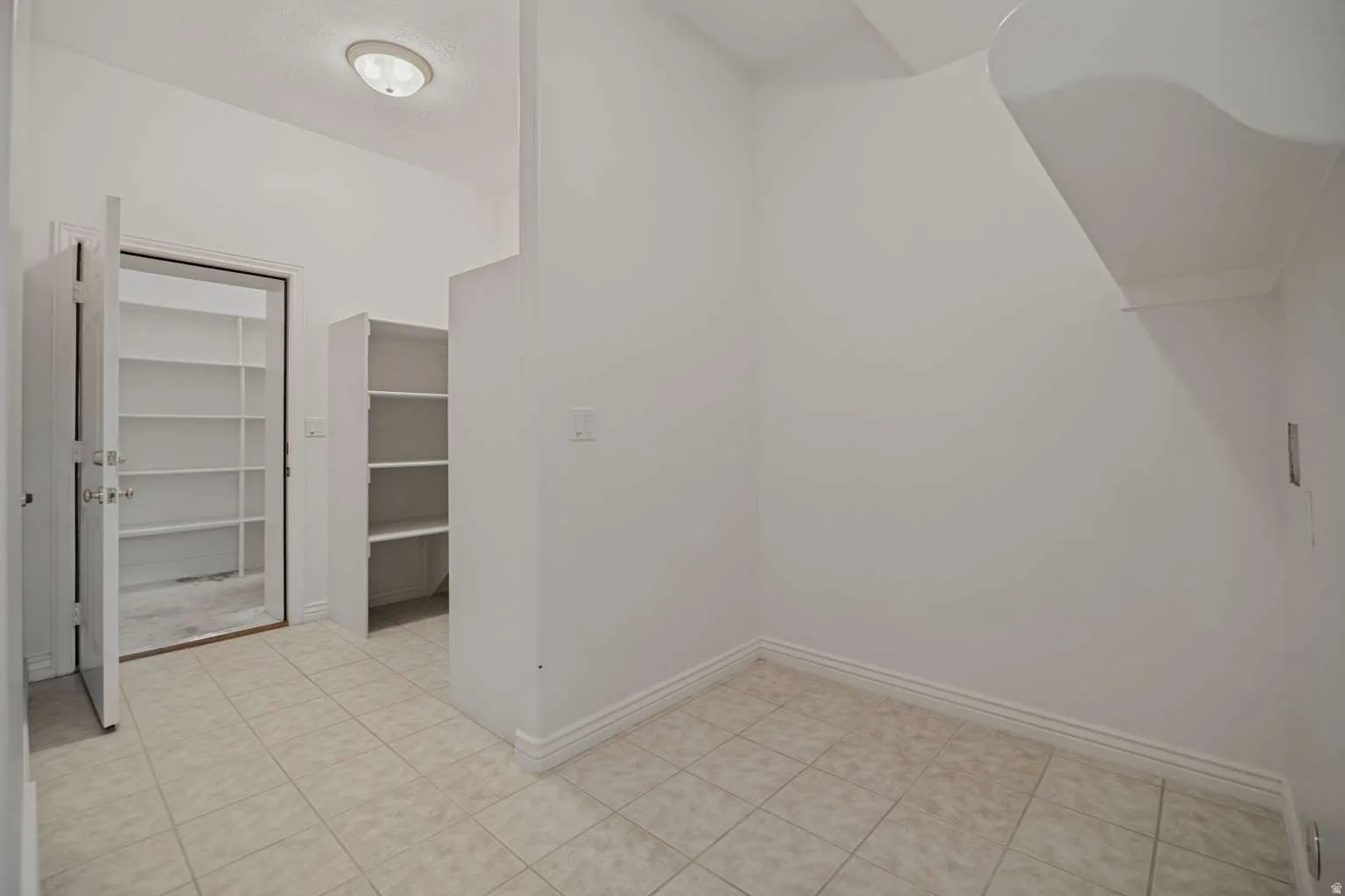 Tile flooring, built-in shelving, flush-mount ceiling light fixture, white interior doors