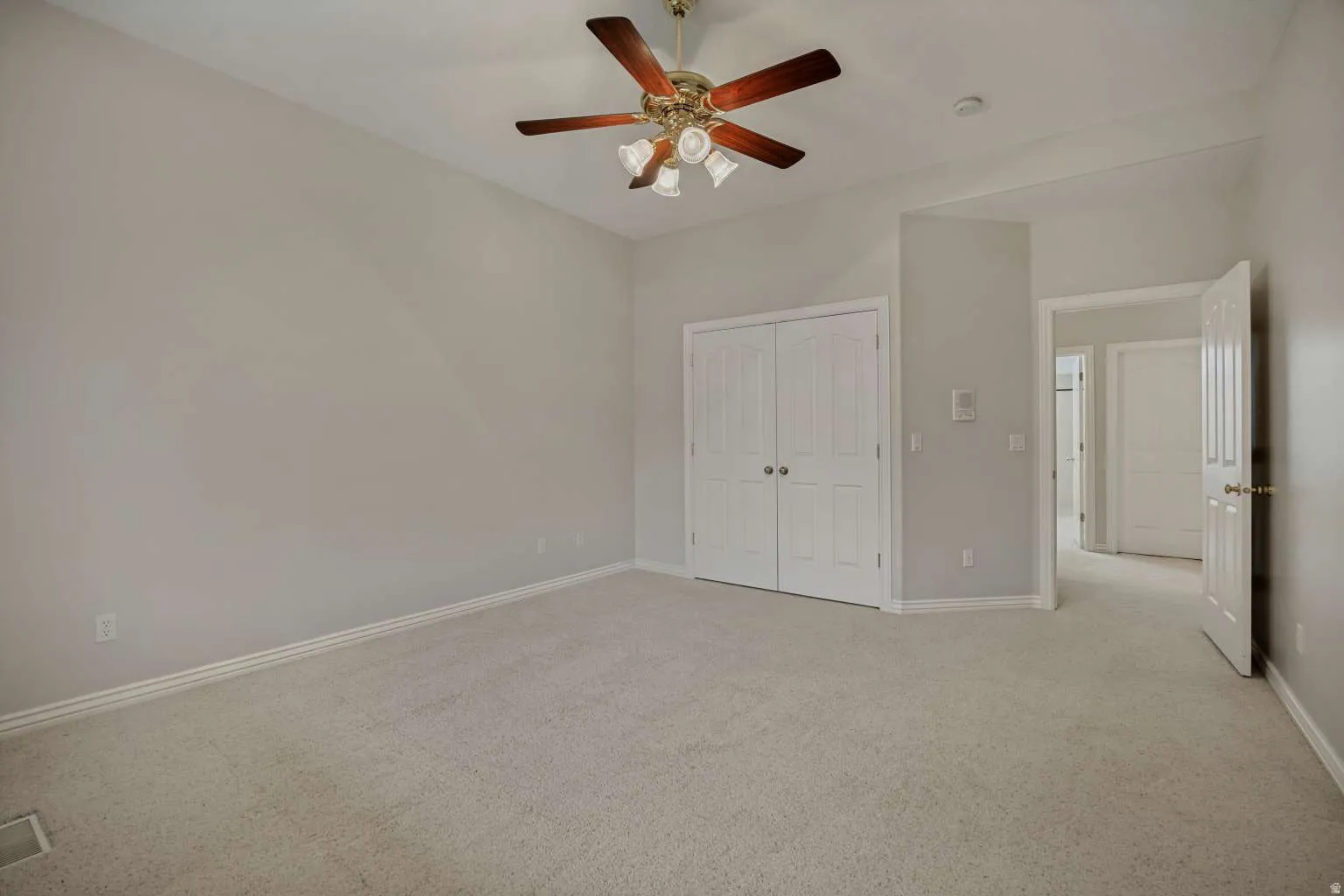 Carpeted flooring, bi-fold closet doors, ceiling fan, and light wall finishes