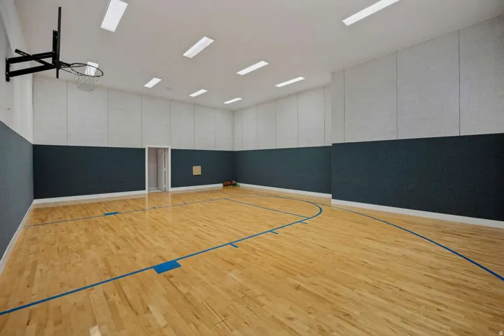 Indoor sports court with hardwood flooring and marked playing lines