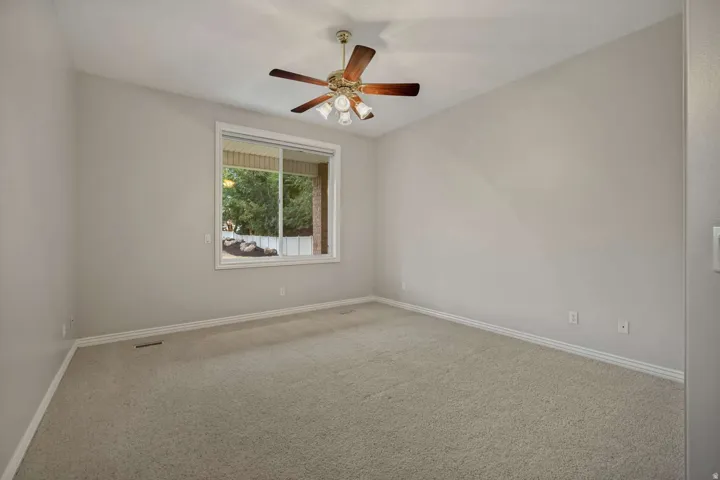Neutral-toned wall paint, recessed window, and ceiling fan with integrated lighting
