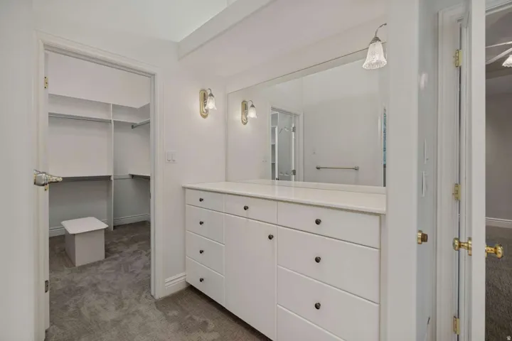Built-in vanity with a full-width mirror, dual wall sconces, and ample storage cabinetry