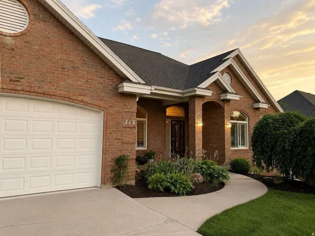 Brick exterior with white trim, arched entryways, and a curved concrete walkway