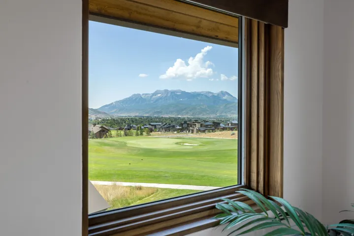 Expansive window framing a golf course and distant mountains