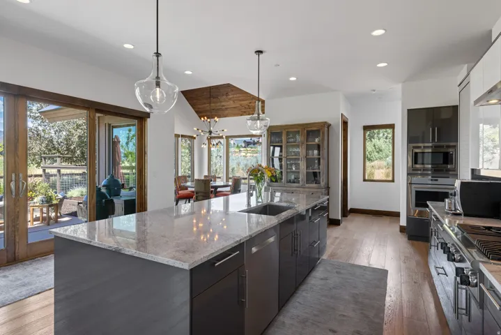 Modern kitchen featuring a large island with a light-toned countertop and dual pendant lighting