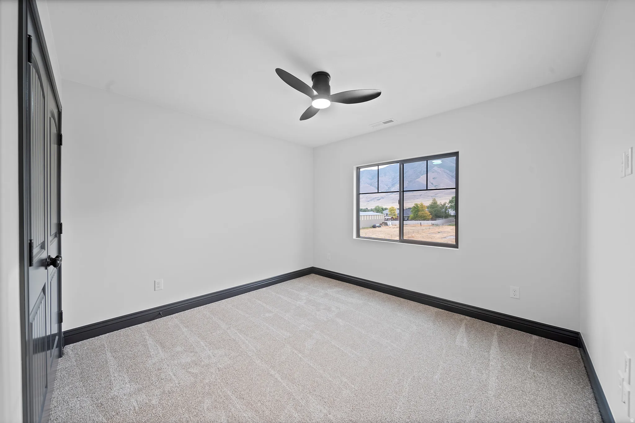 Room featuring neutral carpeting, white walls, and a contemporary ceiling fan