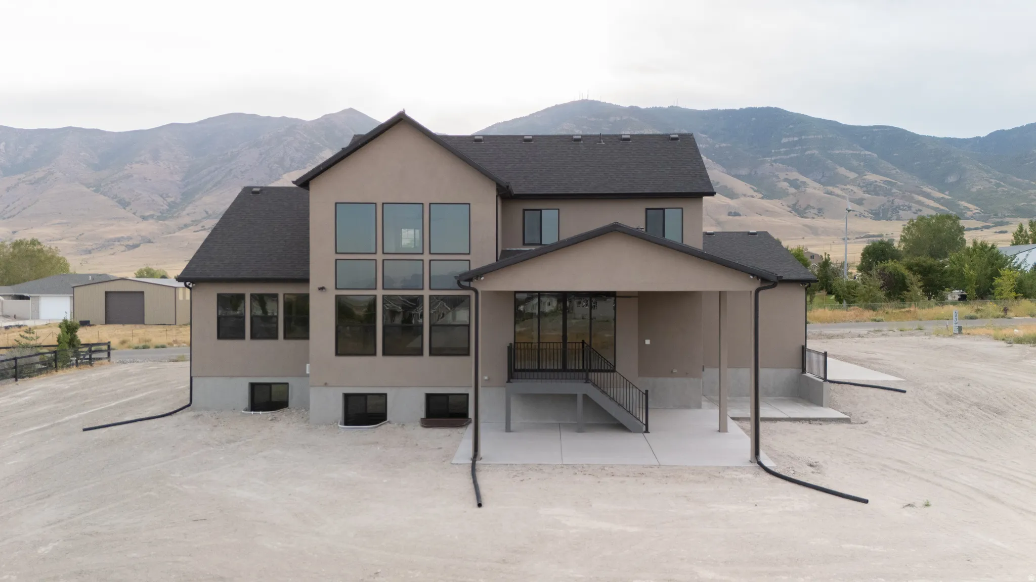 Contemporary stucco exterior with a dark shingle roof