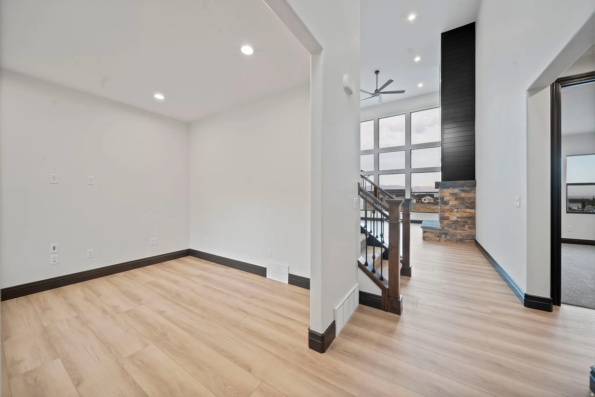 Open concept living area featuring wood-finish flooring, recessed lighting, and dark baseboards