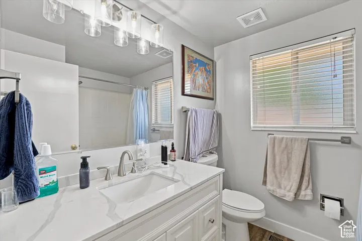 Bathroom with a white vanity featuring a rectangular undermount sink and brushed nickel faucet