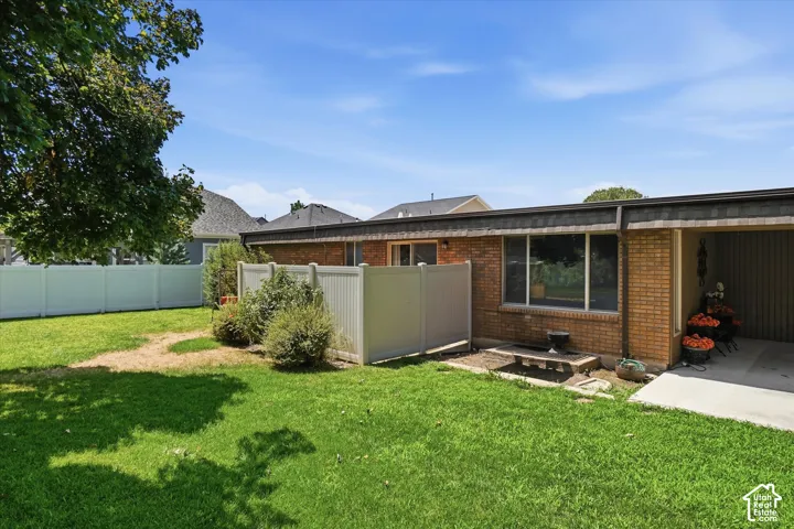 Expansive backyard featuring a manicured lawn, full-height privacy fencing, and mature trees