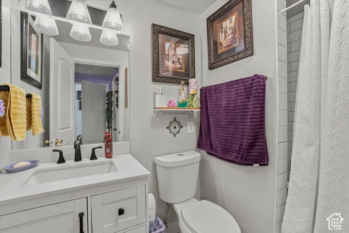 White vanity with a rectangular sink, matte black faucet, and white countertop