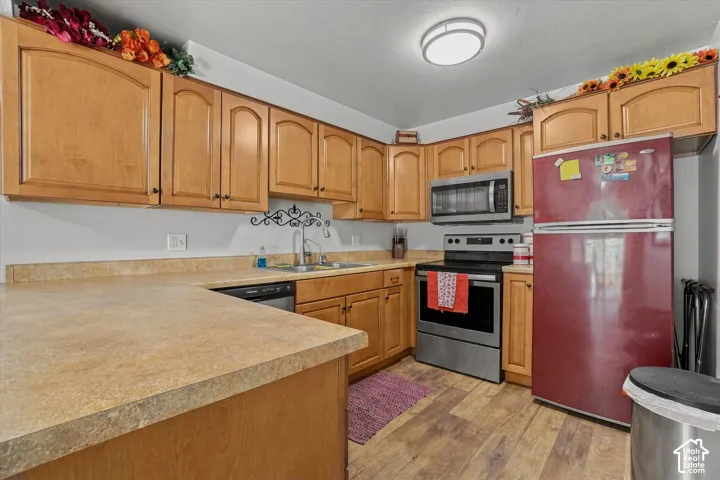 Kitchen featuring light wood cabinetry, stone-finish countertops, and wood-finish flooring