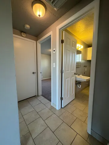 Tiled entryway featuring a flush-mount ceiling light and multiple doorways
