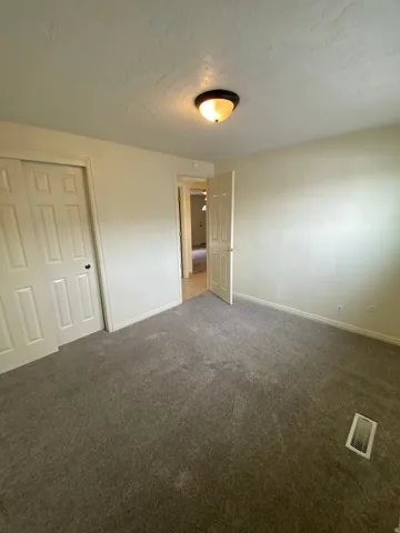 Neutral tone wall paint complements the gray carpeting