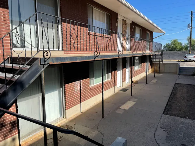 Brick exterior featuring black wrought iron railings and concrete pathways
